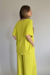Conjunto color lima compuesto por un remerón de lino de corte holgado con cuello en V y un pantalón palazzo con cintura elástica.