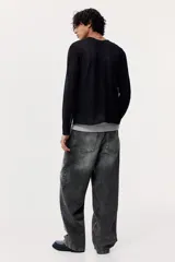 Pantalón de jean gris oscuro con efecto lavado, corte holgado, tiro bajo y cinco bolsillos.