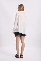 Camisa color visón, de corte holgado y manga larga.