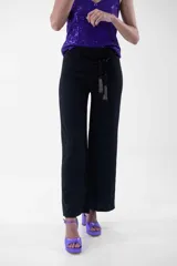 Pantalón negro de corte palazzo con lazo en la cintura.