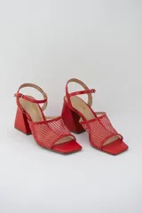 Sandalias rojas con capellada de cuero y rejilla, taco geométrico y pulsera al tobillo.