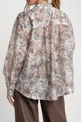 Camisa oversize de mangas largas con puños abotonados, cuello clásico y cierre frontal con botones. Estampado con motivos paisley en tonos pastel.