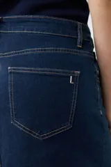 Maxi falda de jean azul oscuro, con tajos y botones dorados.