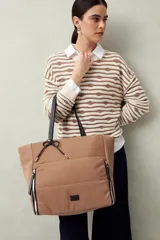 Bolso tote negro de nylon con diseño acolchado, asas largas para llevar al hombro, cierres metálicos laterales y detalle de cordón.