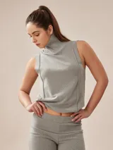 Polera gris melange de tejido de punto con cuello alto y sin mangas.