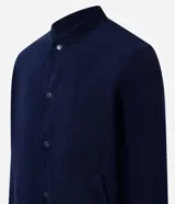 Campera bomber marrón de terciopelo pana con cuello redondo, cierre con botones a presión, bolsillos laterales, puños y cintura elastizados.
