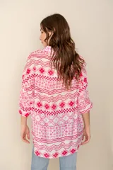 Camisa celeste con estampado de soles, lunas, flores y tortugas en tonos verdes, amarillos y naranjas.