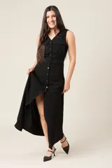 Vestido camisero largo sin mangas color negro, con cuello en V y cierre de botones delanteros. Incluye cinturón ancho a tono y bolsillos estilo safari en el pecho.