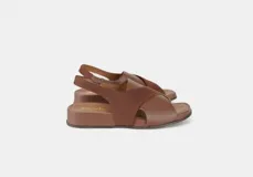 Sandalia de cuero color marrón con tiras cruzadas y talón con elástico interno.