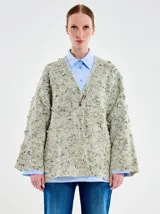 Saco de punto estilo kimono con mangas amplias y silueta relajada. Presenta un cierre frontal mediante un gancho metálico y está confeccionado en una mezcla de lana, nylon y viscosa con una textura moteada.