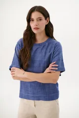 Blusa color crudo de lino con cuello redondo y mangas cortas.