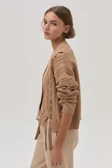 Cárdigan color camel de tejido de punto con trenzas en las mangas y cierre frontal con botones.