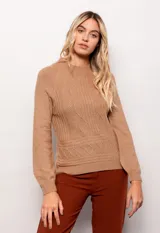 Polera de tejido suave color beige, con diseño de variación de puntos, cuello alto y manga larga.