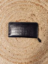 Billetera de cuero con múltiples ranuras para tarjetas y un compartimento con cierre para monedas.