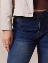 Jean bootcut de tiro alto, marca Harmony & Havoc. Modelo de denim azul con terminación de pierna acampanada, pretina con pasadores, botón y cierre. Delantera con bolsillos inclinados, trasera con bolsillos aplicados.