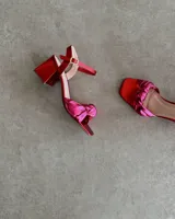 Sandalia plateada de cuero vacuno con taco cuadrado de 6 cm y tira delantera con nudo.