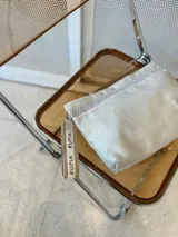 Sobre de mano plateado con detalles en yute y pulsera personalizada con la palabra "RUPIA".