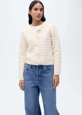 Chaqueta color crema de tejido de punto calado con mezcla de lana, cuello redondo y cierre frontal con botones.