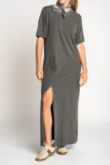 Vestido largo gris oscuro de algodón, con cuello redondo y mangas cortas. Presenta un tajo lateral alto.