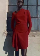 Vestido corto color ladrillo, con escote asimétrico, falda con volados y textura arrugada.