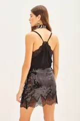 Minifalda negra con lentejuelas y encaje en el ruedo.