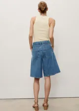 Short de jean azul de corte ancho y largo a la rodilla.
