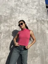 Polera rosa sin mangas, de morley elastizado y cuello alto.