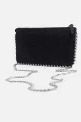Bolso bandolera negro con tachas plateadas en los bordes. Tiene cierre de cremallera y asa de cadena extraíble.