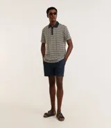 Bermuda de hombre confeccionada en tejido plano de algodón y lino. Presenta cintura elástica con cordón de ajuste, bolsillos laterales y traseros. Sin estampado.