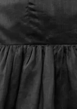 Top palabra de honor negro, con bajo abullonado y cierre de cremallera en la parte posterior.