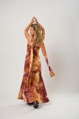 Vestido largo marrón con estampado batik, escote recto, tajo lateral y lazo para atar al cuello.