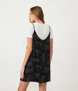 Vestido corto negro con estampado de palabras en blanco y remera blanca de manga corta con estampado de estrellas.