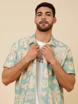 Camisa manga corta celeste con estampado de hojas color beige, cuello clásico y calce regular.