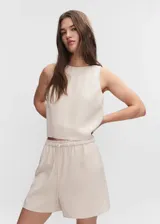 Short de cintura elástica en color beige, con tejido fluido, bolsillos laterales y diseño recto.