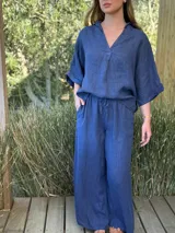 Blusa azul marino de lino, con cuello camisero que forma un escote en V, mangas cortas dobladas y calce holgado.