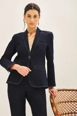Blazer azul marino de denim con forro azul satinado, solapas de muesca, cierre frontal con un botón, bolsillos delanteros con solapa y puños con botones.