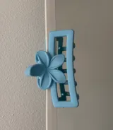 Broche para el pelo de plástico celeste con forma de flor.