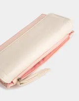 Billetera color rosa pálido con estampado de flores pequeñas, formato fichero con solapa y tag en relieve. Tiene cierre superior con puller, solapa con broche, compartimento para tarjetas y bolsillo interno con solapa.