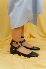 Balerinas negras de cuero con tachas y doble tira con hebillas plateadas.