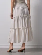 Falda midi a rayas verticales celestes y blancas, con pretina ancha elastizada en punto smock y volados en los cortes.
