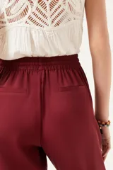 Pantalón tipo babucha color borgoña, de tiro medio y largo al tobillo.