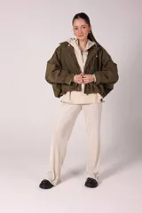 Campera bomber marrón de gamuza sintética con cuello clásico, cierre frontal con botones a presión, bolsillos laterales y charreteras en los hombros.