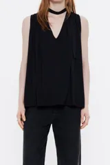 Blusa negra de viscosa con corte línea A, escote en pico con tira en el cuello con botón, manga sisa y minipliegues en hombros para dar volumen.
