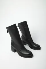 Bota biker de punta redonda confeccionada en cuero vacuno soft, con cierre trasero y taco ancho.
