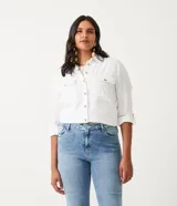 Camisa blanca de manga larga con cuello camisero, cierre frontal con botones a tono, dos bolsillos con solapa en el pecho y puños con trabilla.