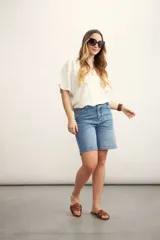 Blusa rosa de lino con escote cruzado en V y mangas cortas. Incluye un collar con cordón negro y dije dorado.