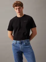 Remera negra de manga corta con cuello redondo y logo de Calvin Klein Jeans estampado en el pecho.