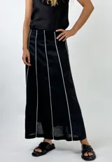 Conjunto de top con breteles finos y pollera larga marrón con líneas verticales blancas.