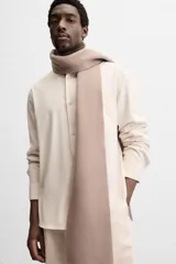 Camisa color crema de corte regular fit, confeccionada en tejido con viscosa. Tiene cuello solapa, manga larga con puños abotonados, bolsillo de parche en el pecho y cierre frontal con botones.