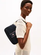 Cartera de hombro Tommy Hilfiger color azul marino, con correa de hombro y correa bandolera extraíble. Presenta una franja vertical con el logo de la marca en el centro.